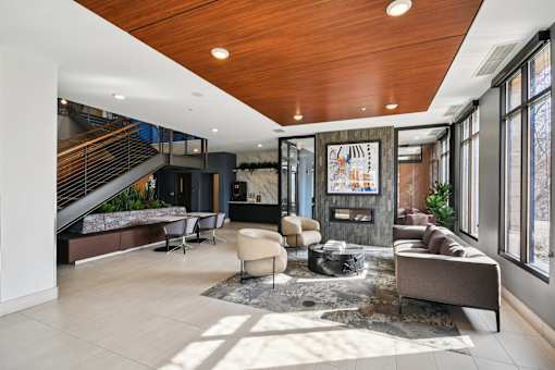 A modern living room with a wooden ceiling and a staircase.