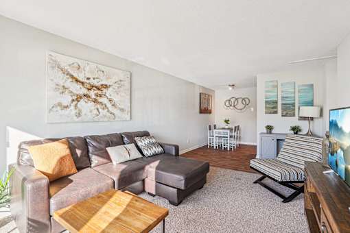 A living room with a brown leather couch and a wooden coffee table.