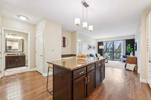 A kitchen with a granite countertop and wooden floors.