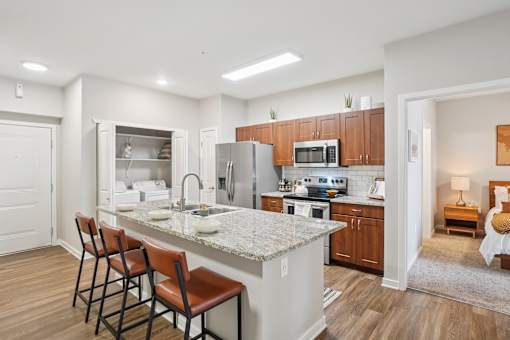 A kitchen with a marble countertop and wooden cabinets.