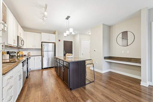 A kitchen with a refrigerator, microwave, and oven.