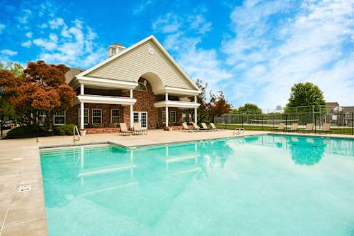 A house with a pool in front of it.