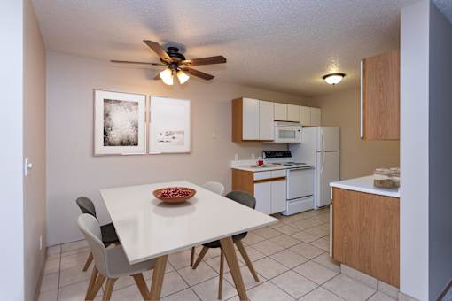 Kitchen with White Cabinets and Open Dining Room with Table