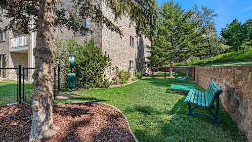 our apartments have a small yard with a bench and a tree