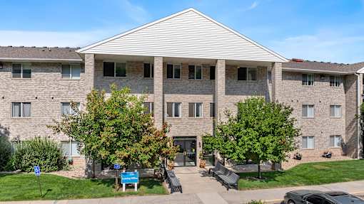 a brick apartment building with trees in front of it