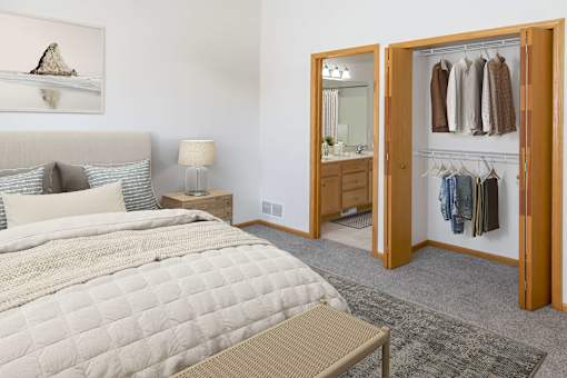 a bedroom with a large bed and a bathroom in the background