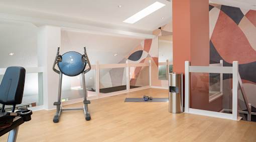 a workout room with a blue exercise ball and a treadmill