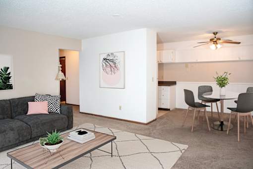 a living room with a couch a table and a ceiling fan