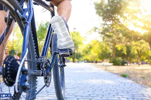 a person riding a bike down a street with their foot on the pedal