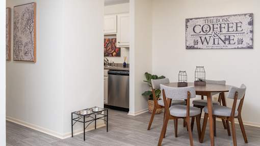 a dining room with a table and chairs and a sign that reads coffee and wine at The Bosk Apartment Homes, Minnesota