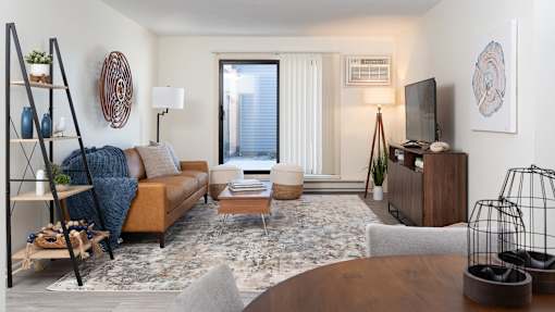a living room with a couch and a table and a tv at The Bosk Apartment Homes, Woodbury, Minnesota