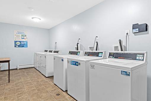 A laundromat with washers and dryers lined up.