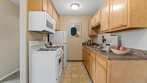 our apartments have a kitchen with white appliances and wood cabinets
