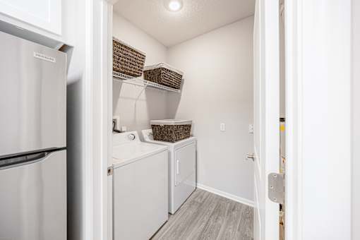 A white refrigerator is on the left of a small kitchen.