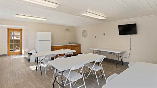 a dining room with tables and chairs and a television