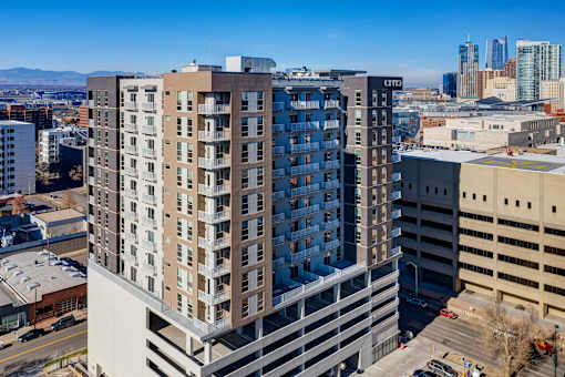 Exterior view of Civic Lofts building and parking structure, with view of Denver skyline