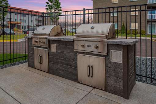 Community grills in a fenced in community space.