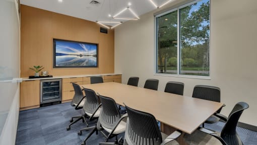 a conference room with a large window and a table and chairs