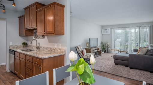 a kitchen with wooden cabinets and a table with chairs