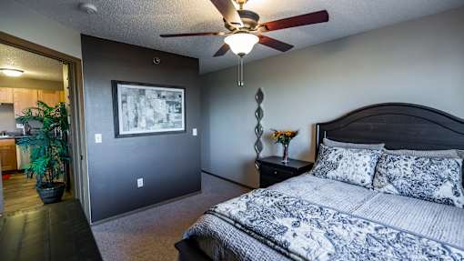 the master bedroom has a large bed and a ceiling fan