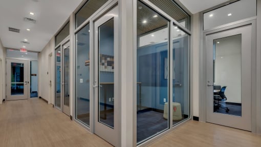 a corridor with glass doors and a wood floor