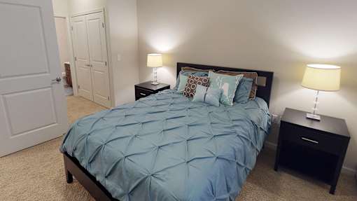 a bedroom with a bed and two night stands and a closet