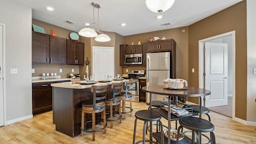 A kitchen with brown cabinets and a white island.