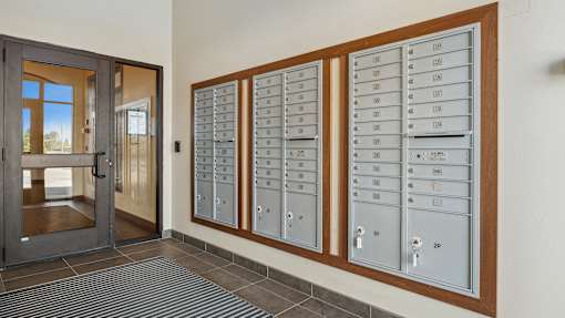 A set of mailboxes are lined up on a wall.