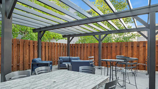 A patio with a table and chairs under a roof.