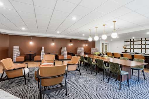 A room with brown chairs and tables with a checkered floor.
