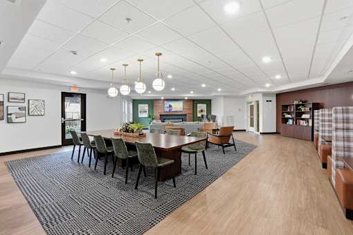 A conference room with a long table surrounded by chairs.
