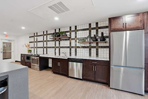 A kitchen with a stainless steel refrigerator and wooden cabinets.