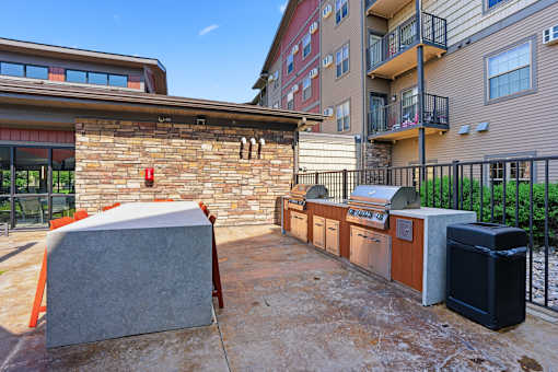 A patio area with a grill and a hot tub.