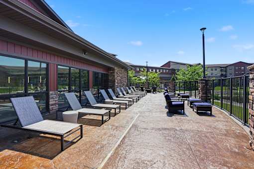 A row of lounge chairs are set up on a patio.