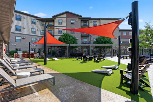 A sun shade is over a picnic table and chairs.
