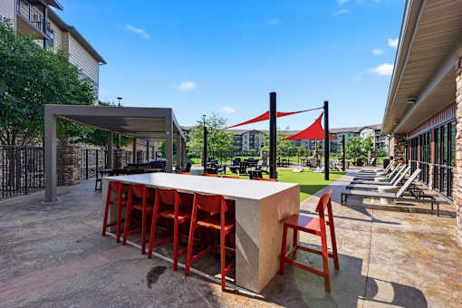 A patio with a bar and chairs.