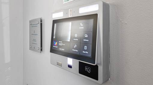 A wall-mounted control panel with a screen and buttons for various functions.