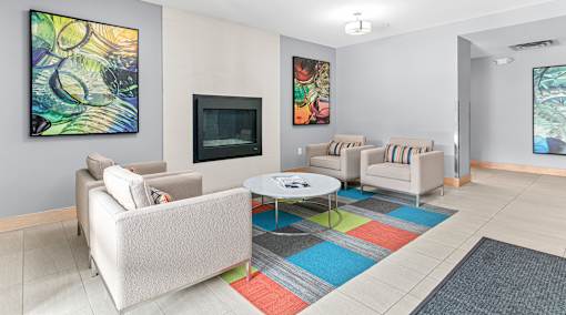 A living room with a white couch, a coffee table, and a painting on the wall.