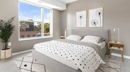 A bedroom with a large bed and a potted plant.