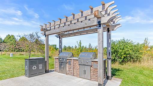 a pergola with three trash bins in a park