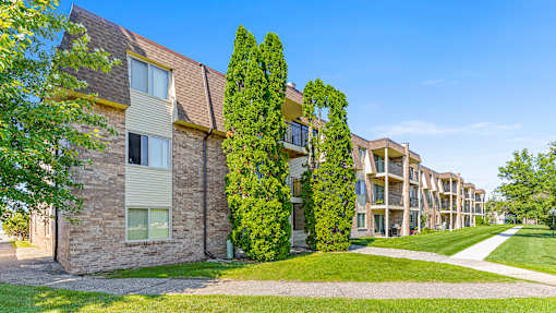 an apartment building with two trees in front of it