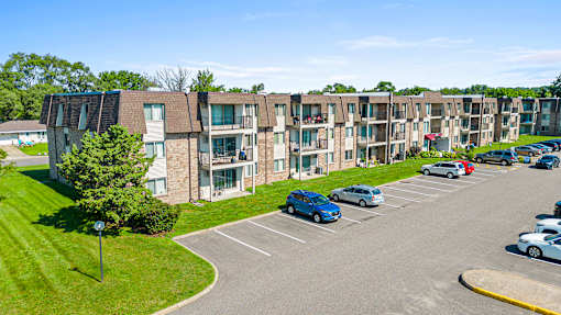 an aerial view of an apartment complex with cars parked in a parking lot