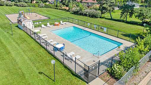 a swimming pool in a backyard with a fence around it