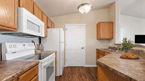 a kitchen with white appliances and wooden cabinets