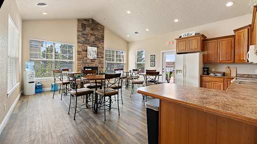 the kitchen and dining area of a home with a table and chairs