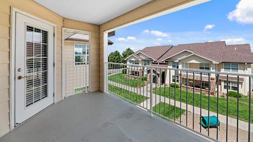 the view from the balcony of a house with a yard and a white door