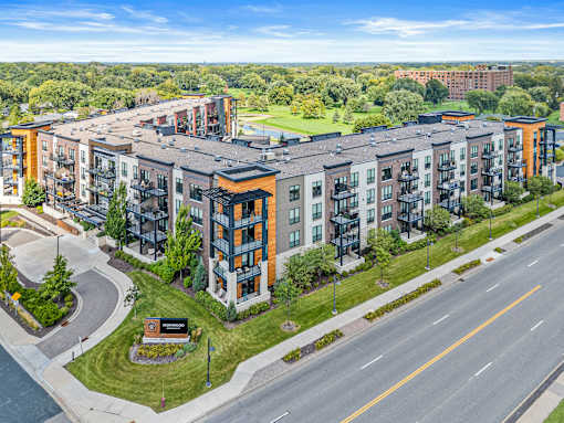 A large apartment complex with a green lawn in front.