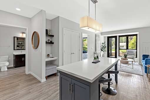 A modern kitchen with a large island and a view of the backyard.