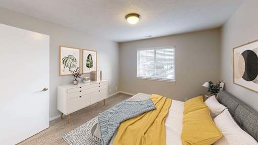 Spacious bedroom with a large window letting in natural light.