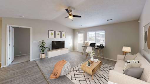 Spacious and airy living area in a top unit with vaulted ceilings and a large window.